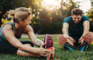 Man and woman stretching outdoors.