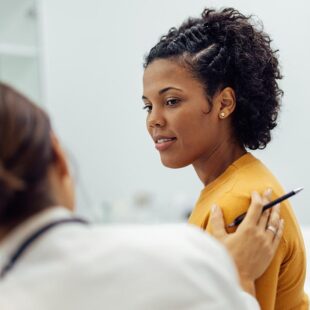 Physician reassuring female patient.