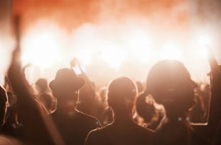 Happy friends laughing and having fun outdoors at concert