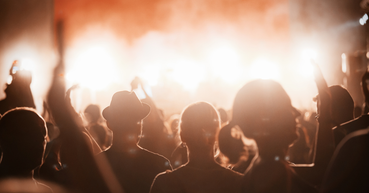 Happy friends laughing and having fun outdoors at concert