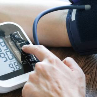 Man checks blood pressure monitor and heart rate monitor with digital pressure gauge.