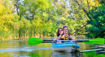 mother and child paddling in kayak on river canoe tour