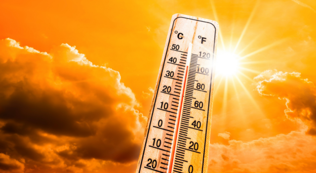 Hot summer or heat wave background, glowing sun on orange sky with thermometer