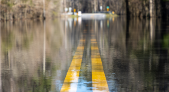 A road is unpassable to cars after a nearby river overtopped its banks after days of rain, flooding it. South Carolina.