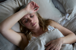 Menopausal Mature Woman Suffering With Insomnia In Bed At Home