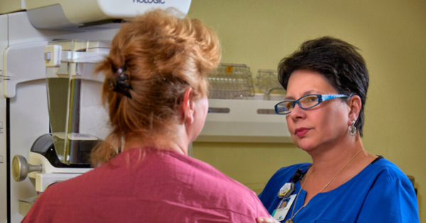 A mammography technician comforts a patient during her mammogram.