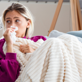 Young Woman Infected With Cold Blowing Her Nose In Handkerchief.