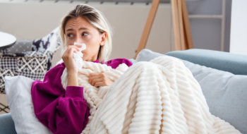 Young Woman Infected With Cold Blowing Her Nose In Handkerchief.